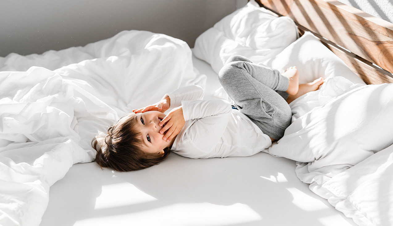 Allergikerbettwäsche Kind liegt auf einem Bett