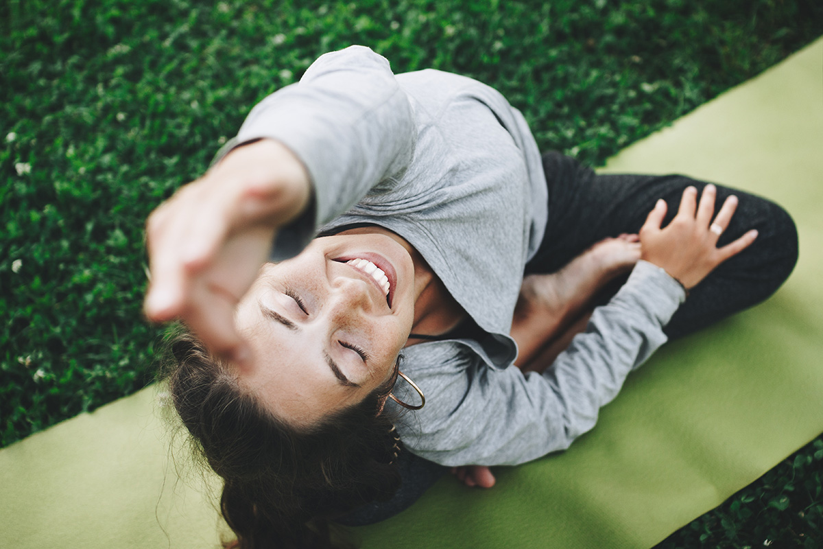 Frau, die bei einer Gesundheitsreise an einer Yogastunde im Freien teilnimmt