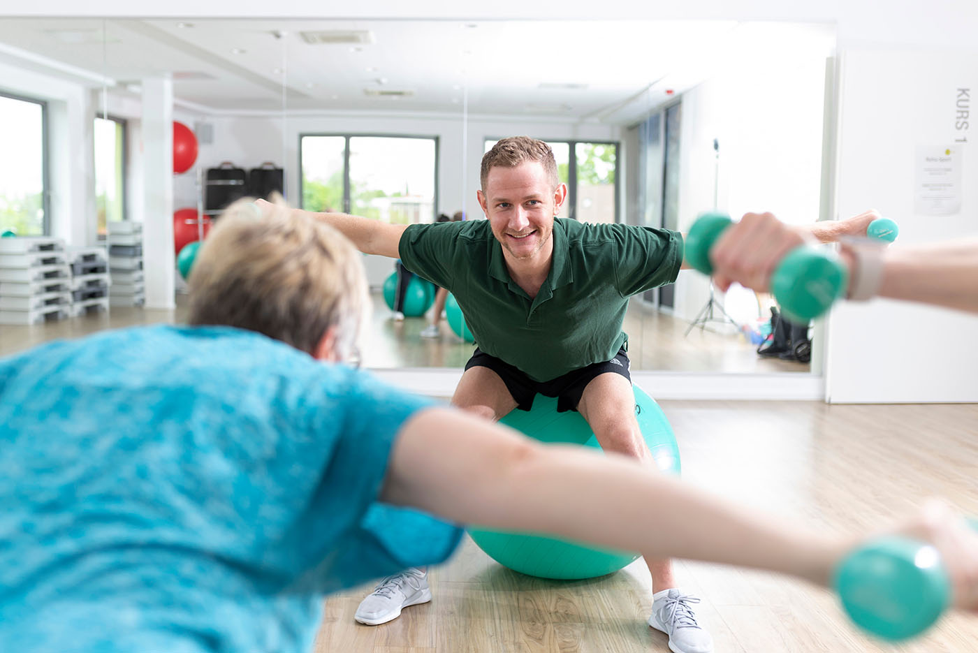Reha-Sport Fitness-Traininger beim Reha-Sport mit Hanteln