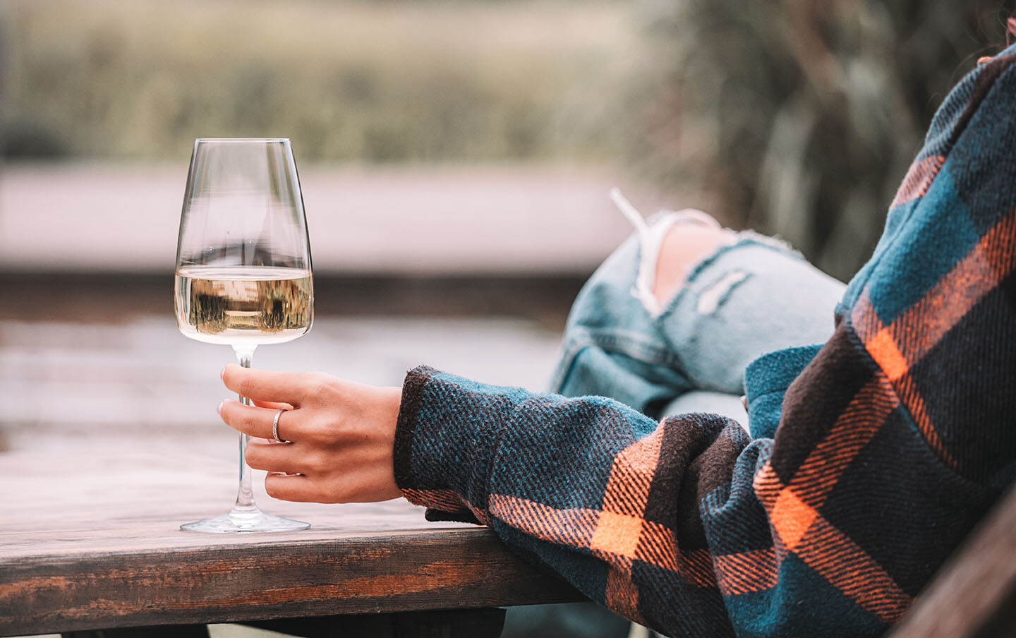 Frauenhand mit einem kleinen Glas Wein