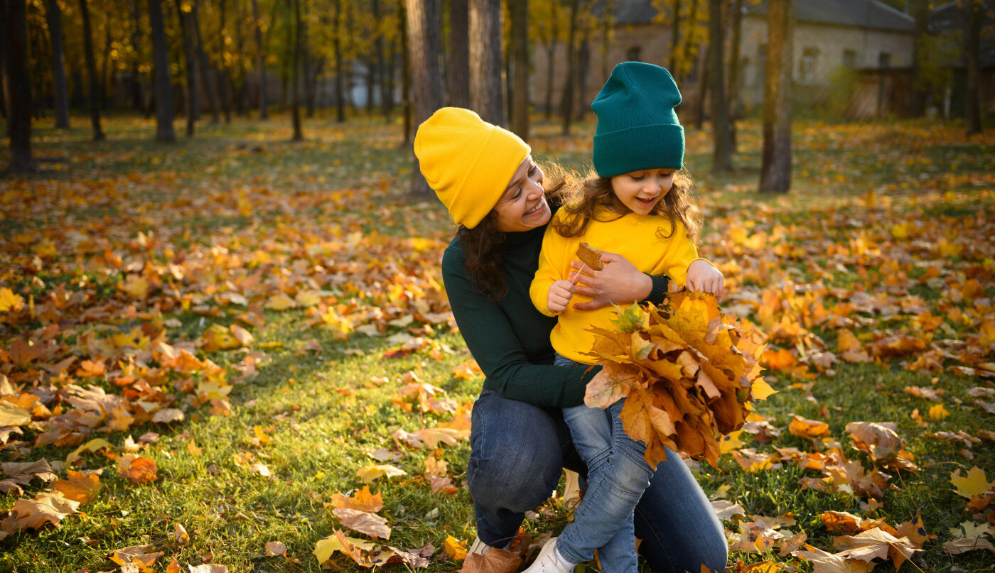 Mutter mit Mädchen im Herbstwald mit bunten Blättern
