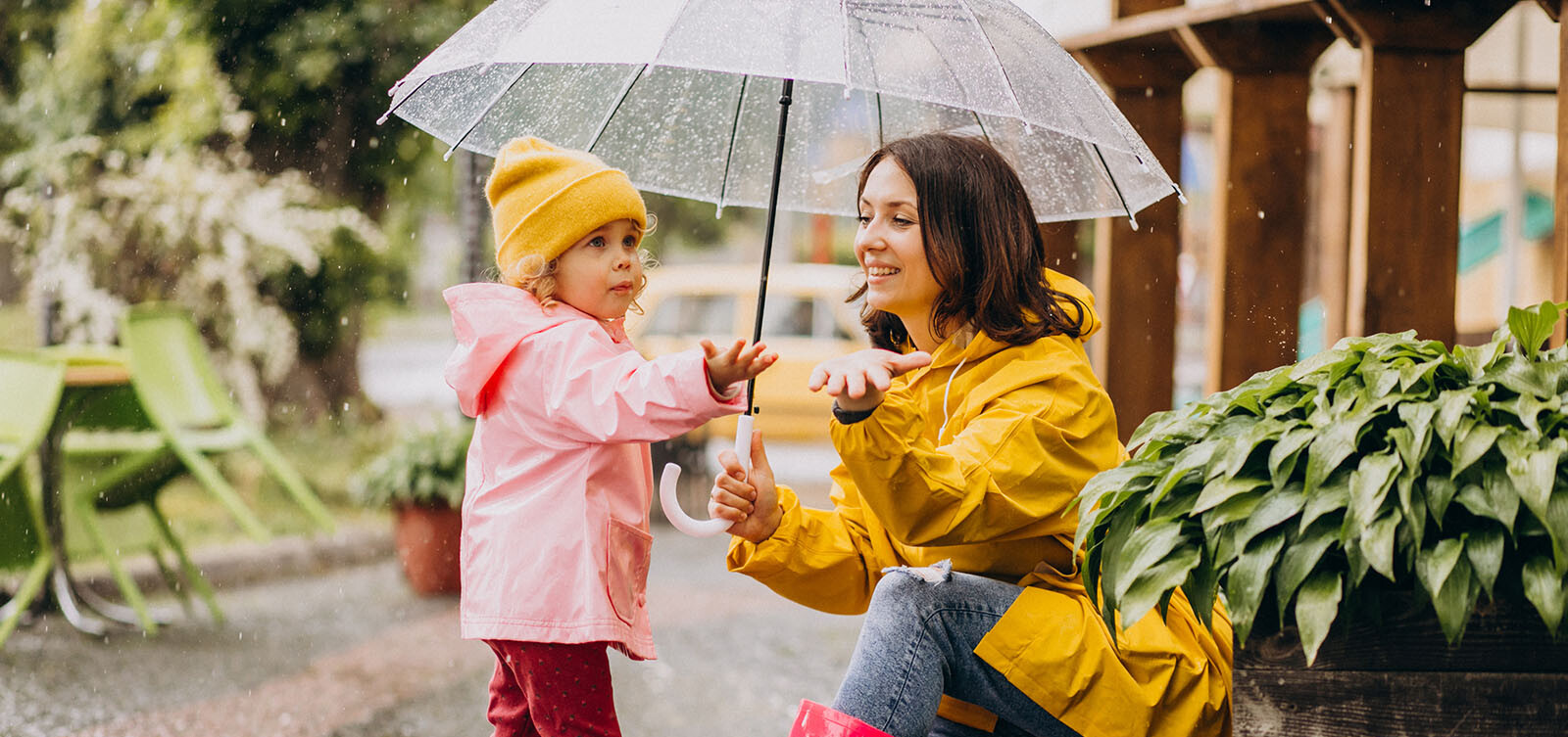 Mutter mit ihrer kleinen Tochter unter einem Regenschirm