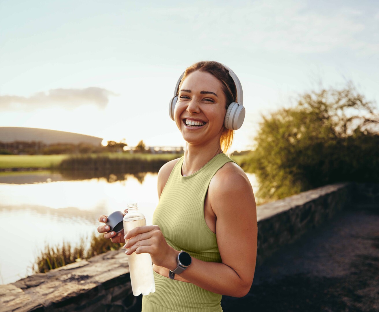 Frau sitzt auf dem Boden lächelt und hört Musik.