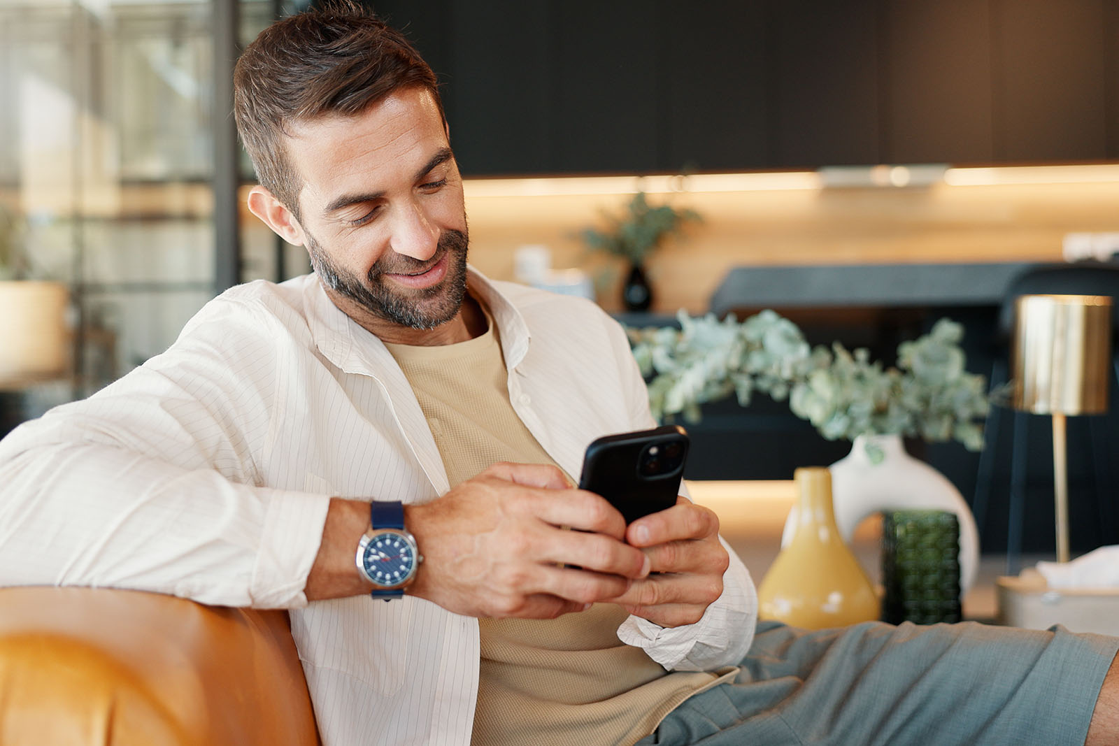 Ein Mann schaut zufrieden auf sein Handy