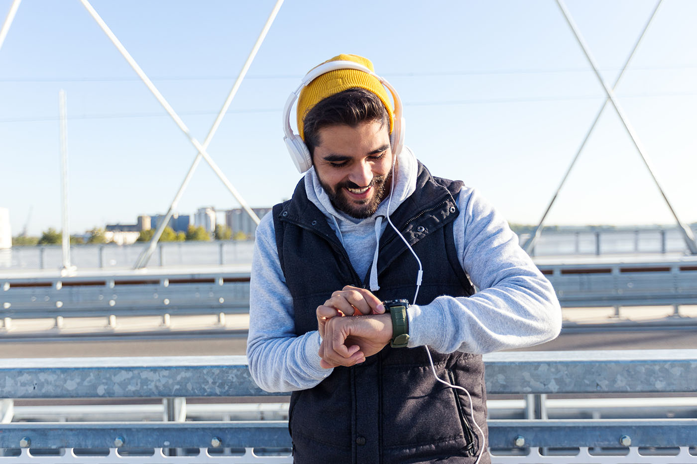 Mann, der beim Outdoorsport auf seine Fitnessuhr schaut
