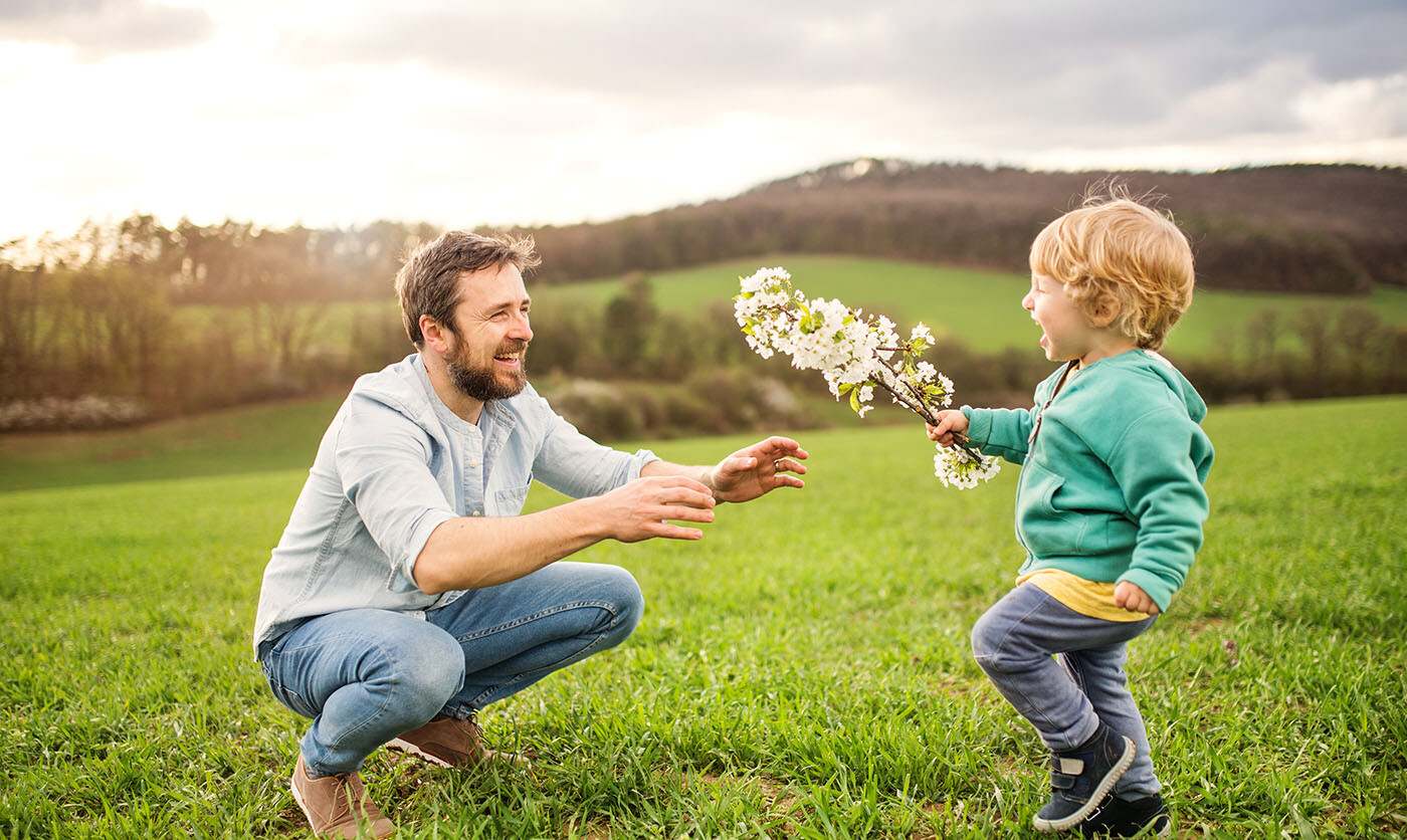 Kleiner Junge, der dem Vater einen Frühlingszweig bringt