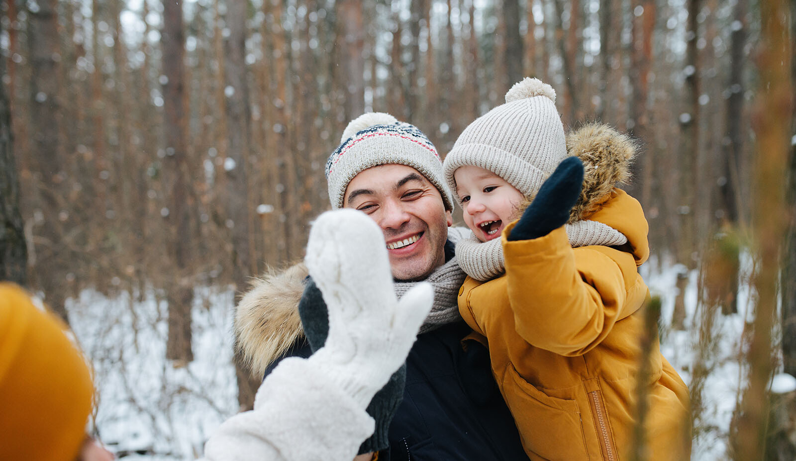 Junge Familie beim Winterspaziergang im Wald