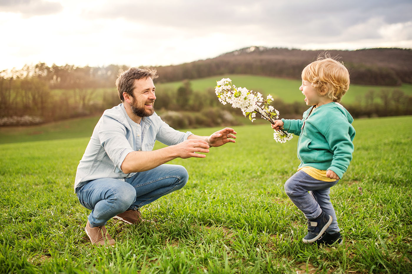 Kleiner Junge, der dem Vater einen Frühlingszweig bringt