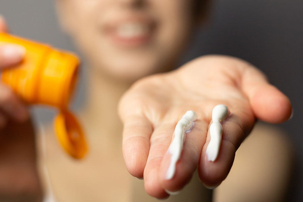 Hand mit Sonnencreme darauf