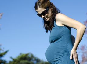 Schwangere hält sich den Rücken