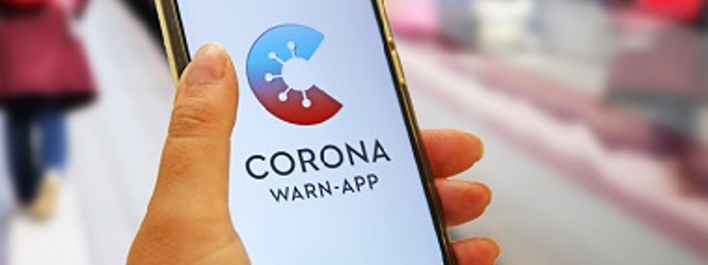 Jemand hält ein Handy mit geöffneter Corona-Warn-App in der Hand